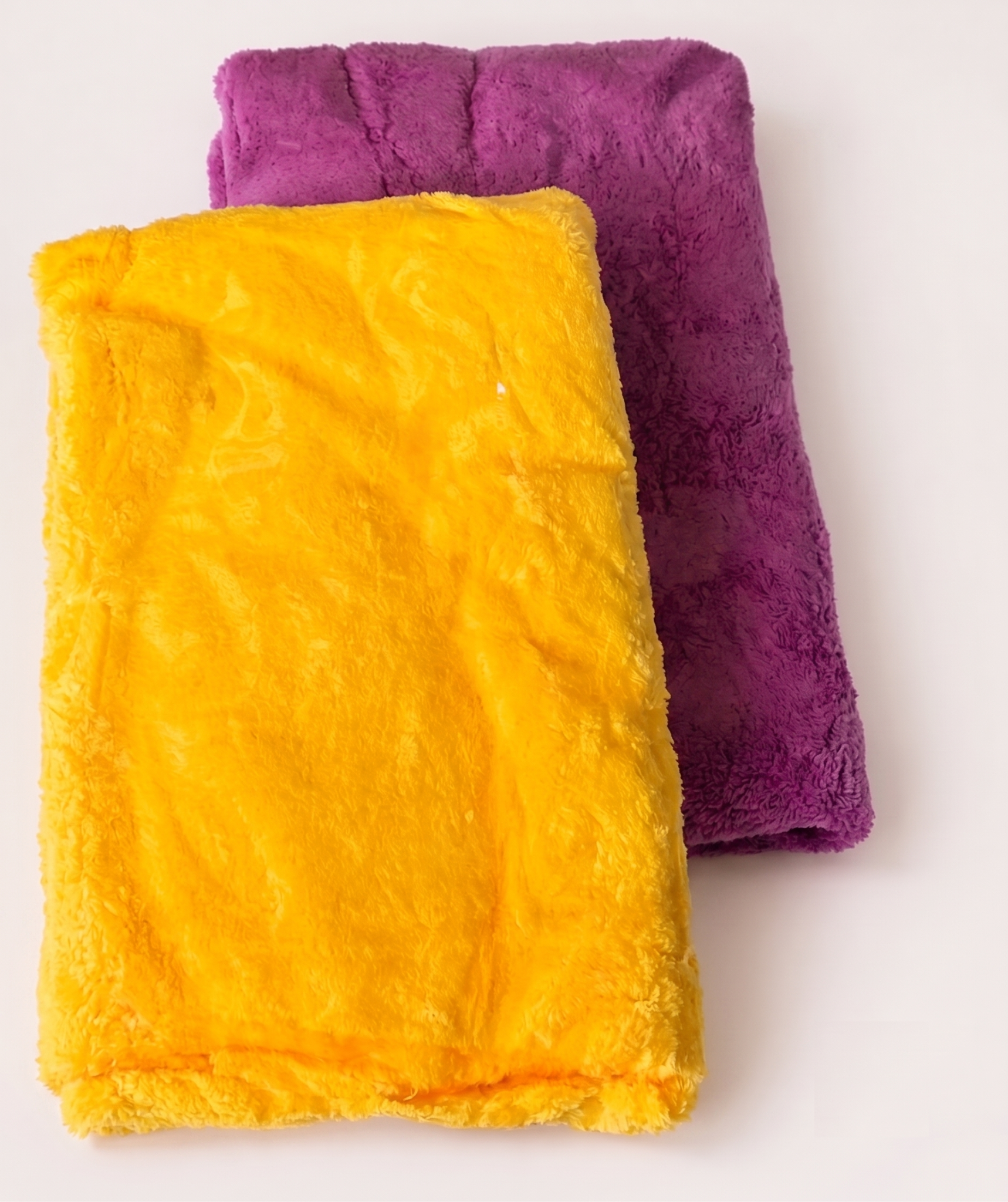 Two folded Fixtr 400 GSM coral-fleece microfiber cloths in illustrative yellow and purple assorted colours